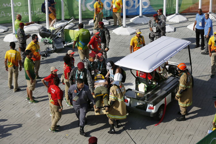 An injured woman is taken away on a backboard after being struck by an overhead television camera in Rio. (AP/Robert F. Bukaty)</p>  