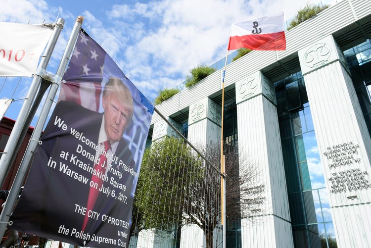 A poster of Trump hangs in Warsaw, outside the memorial where the president will speak on Thursday. (Marcin Kmiecinski/European Pressphoto Agency)</p>  