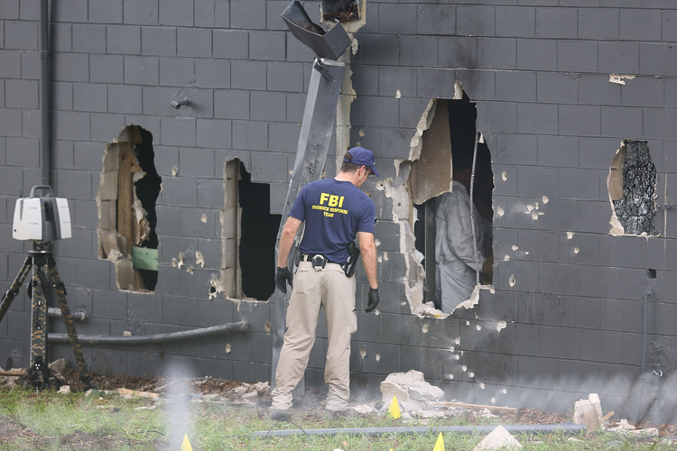 FBI agents investigate the damaged rear wall of the Pulse Nightclub.&nbsp;(Photo by Joe Raedle/Getty Images)</p>  