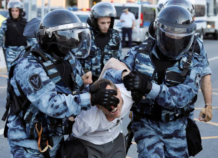 Cops arrest a man in Moscow on Saturday for participating in a protest to call for opposition candidates to be allowed to appear on the ballots for municipal elections. (Shamil Zhumatov/Reuters)  