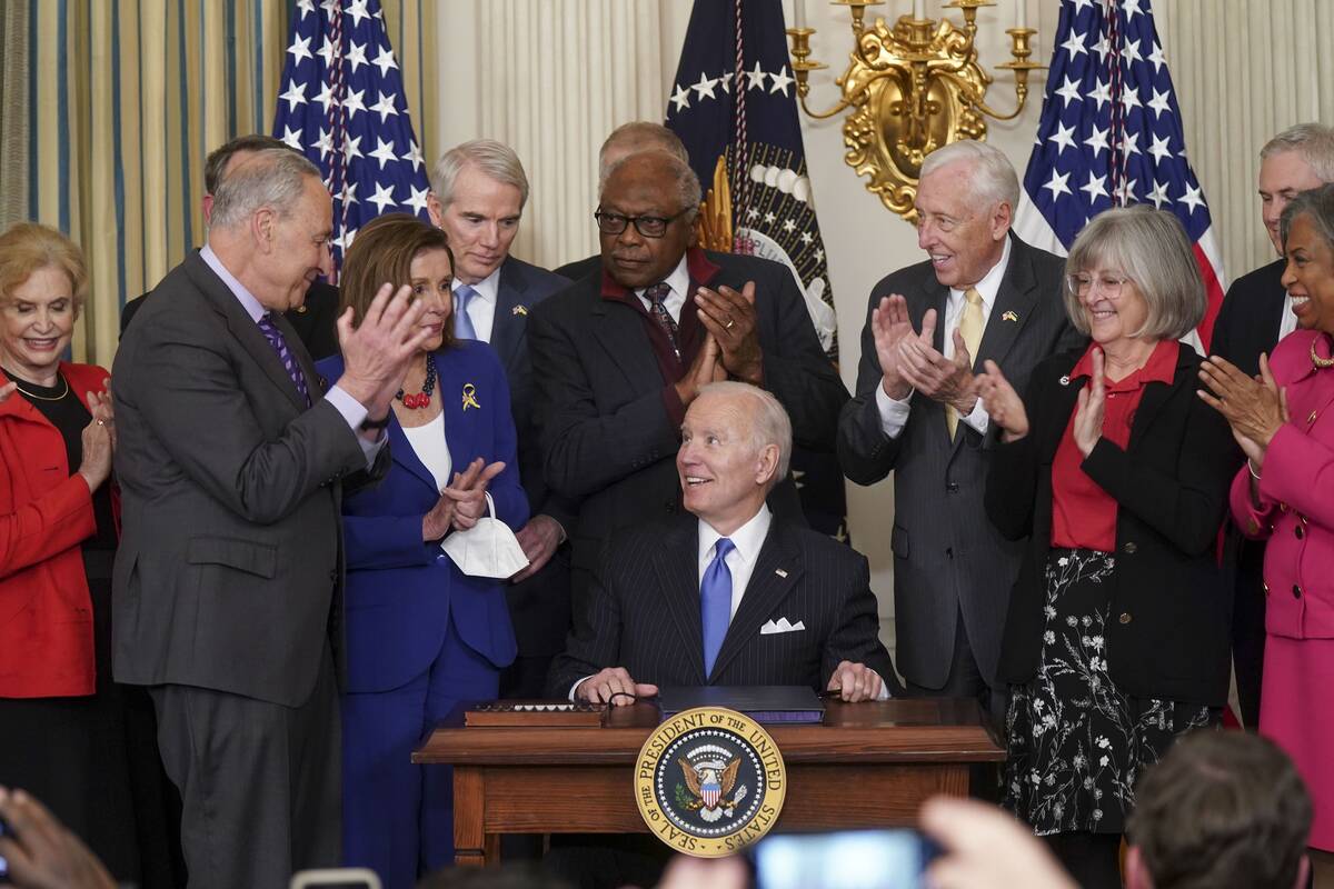 President Biden signs the Postal Service Reform Act on Wednesday. (Leigh Vogel/The Washington Post)