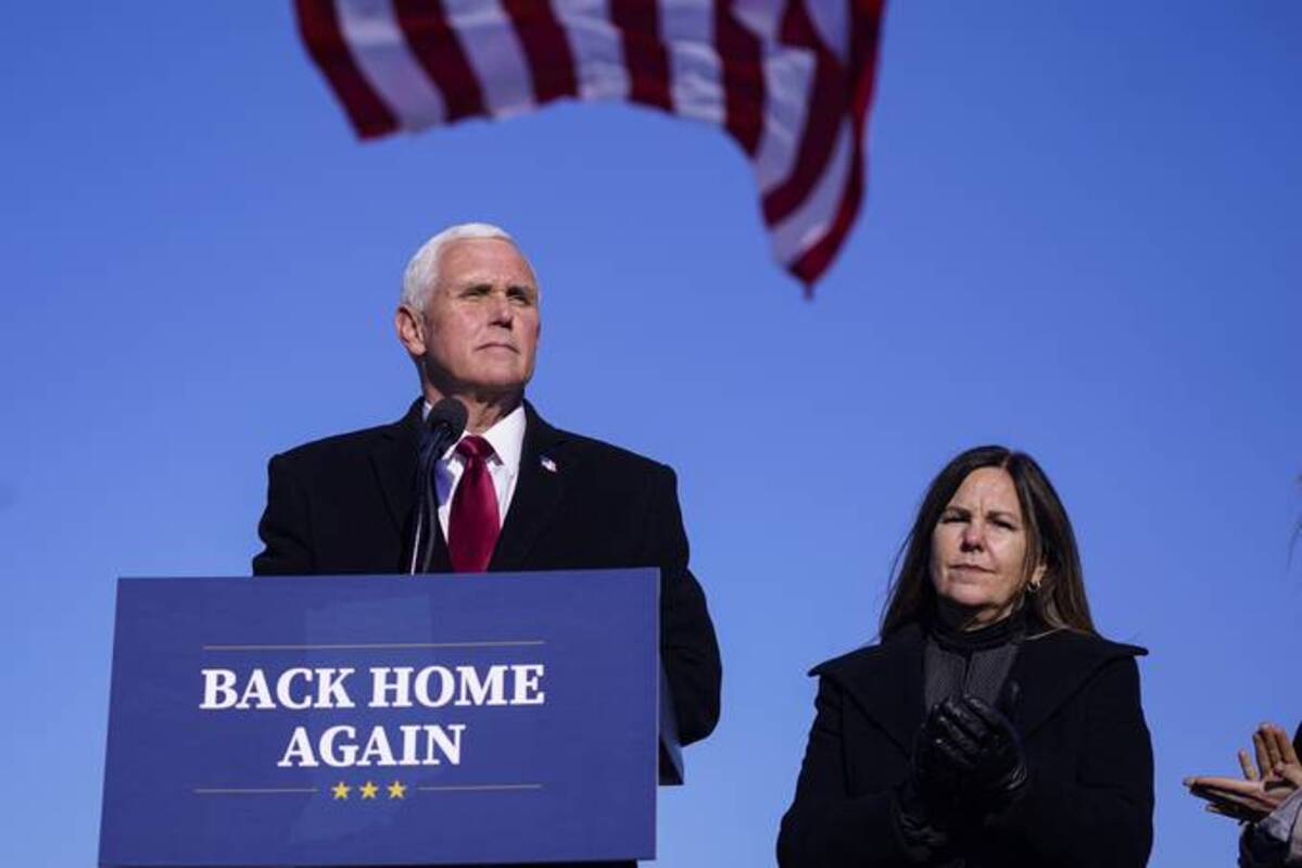 Former vice president Mike Pence speaks after arriving back in his hometown of Columbus, Ind., as his wife Karen watches. (Michael Conroy/AP)