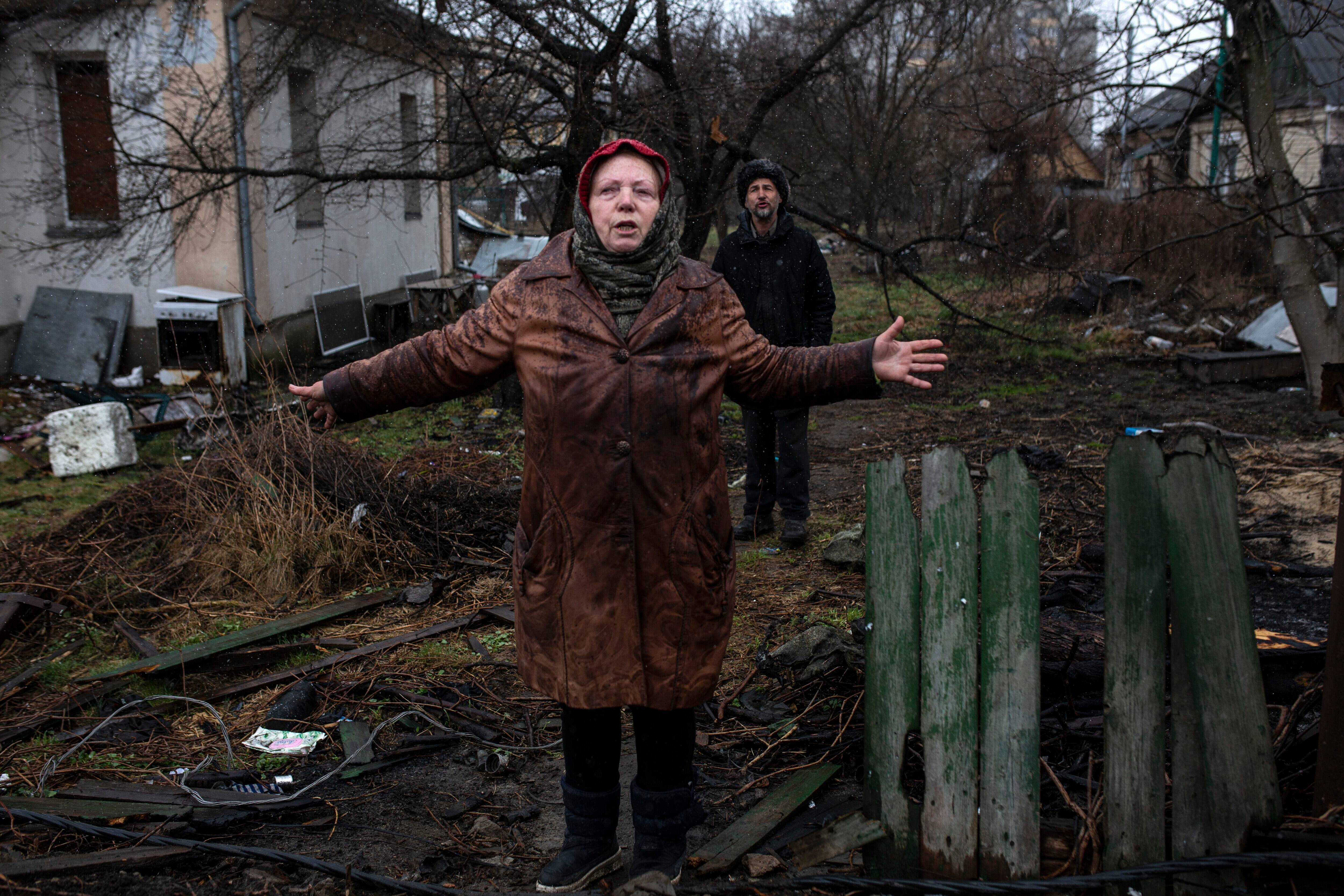 Larisa Savenko stands outside her damaged home with Andriy Leshbon in Bucha, Ukraine on April 3. (Heidi Levine for The Washington Post)