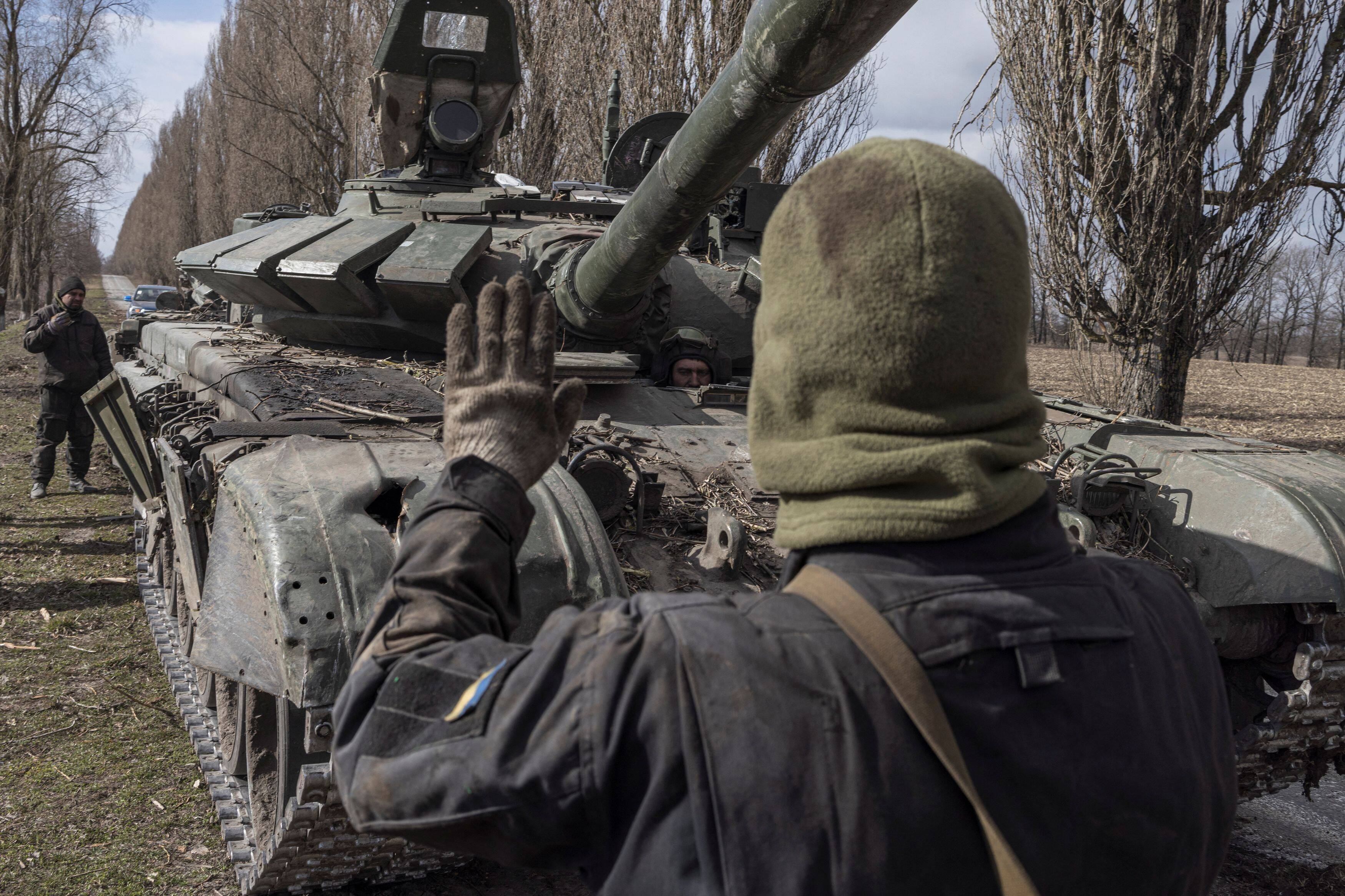 A Ukrainian serviceman walks past a Russian tank captured after fighting with Russian troops outside Kyiv on March 27. (Marko Djurica/Reuters)
