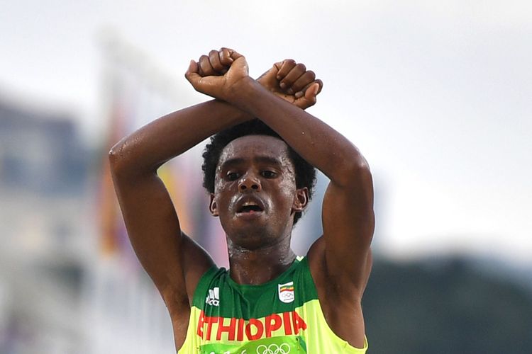 Ethiopia's Feyisa Lilesa crossed his arms above his head at the finish line in Rio. (Oliver Morin/Getty)</p>  