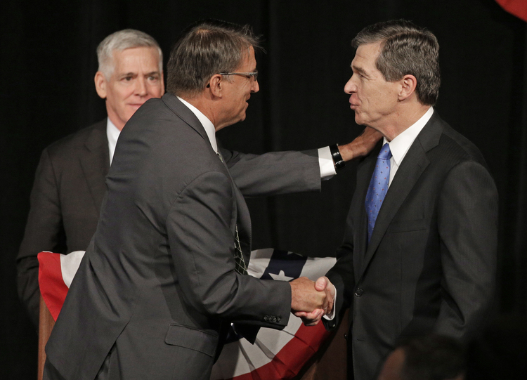 North Carolina Gov. Pat McCrory, left, shakes hands with Attorney General Roy Cooper, right, after a debate in Charlotte on June 24.&nbsp;(AP Photo/Chuck Burton)</p>  