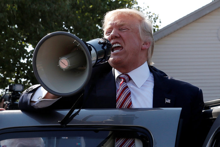 Trump speaks to supporters through a bullhorn in September. (Reuters/Mike Segar)</p>  