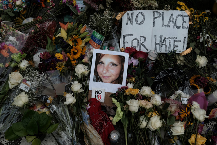 A photograph of Charlottesville victim Heather Heyer is seen among flowers left at the scene of the car attack that killed her. (Justin Ide/Reuters)  