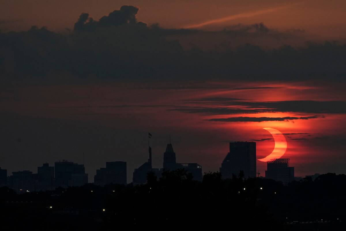 A partial solar eclipse and the Baltimore skyline on June 10. (Julio Cortez/AP)