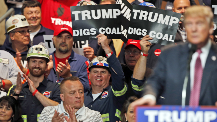 Coal miners wave signs during a Trump rally last May in Charleston, W.Va. (Steve Helber/AP)</p>  