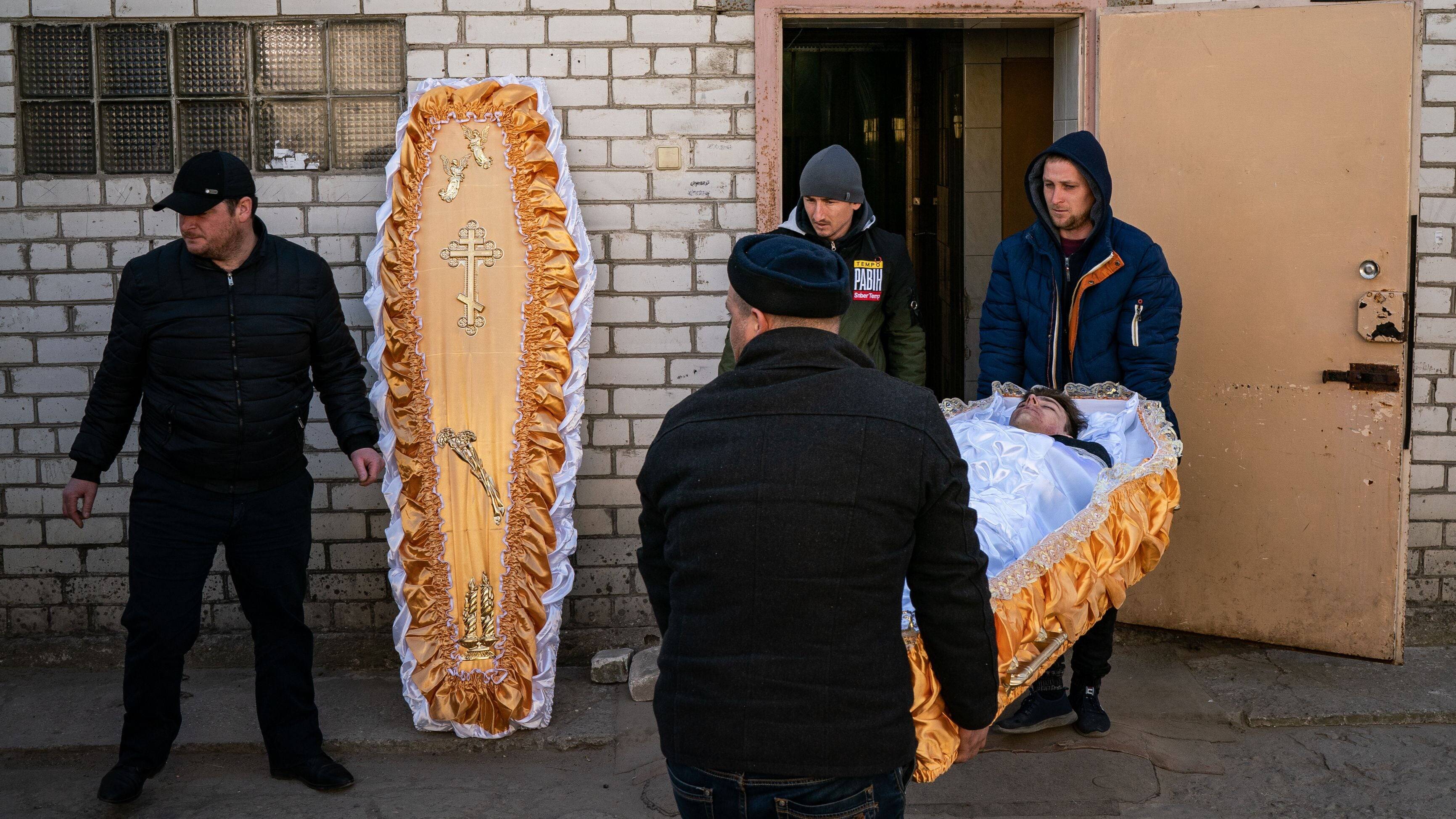 The body of the 17-year-old Danil, is moved from a room full of bodies of Ukrainian soldiers to a van to be taken with his family to the cemetery from the city's morgue in Mykolaiv, Ukraine on March 21. (Salwan Georges/The Washington Post)