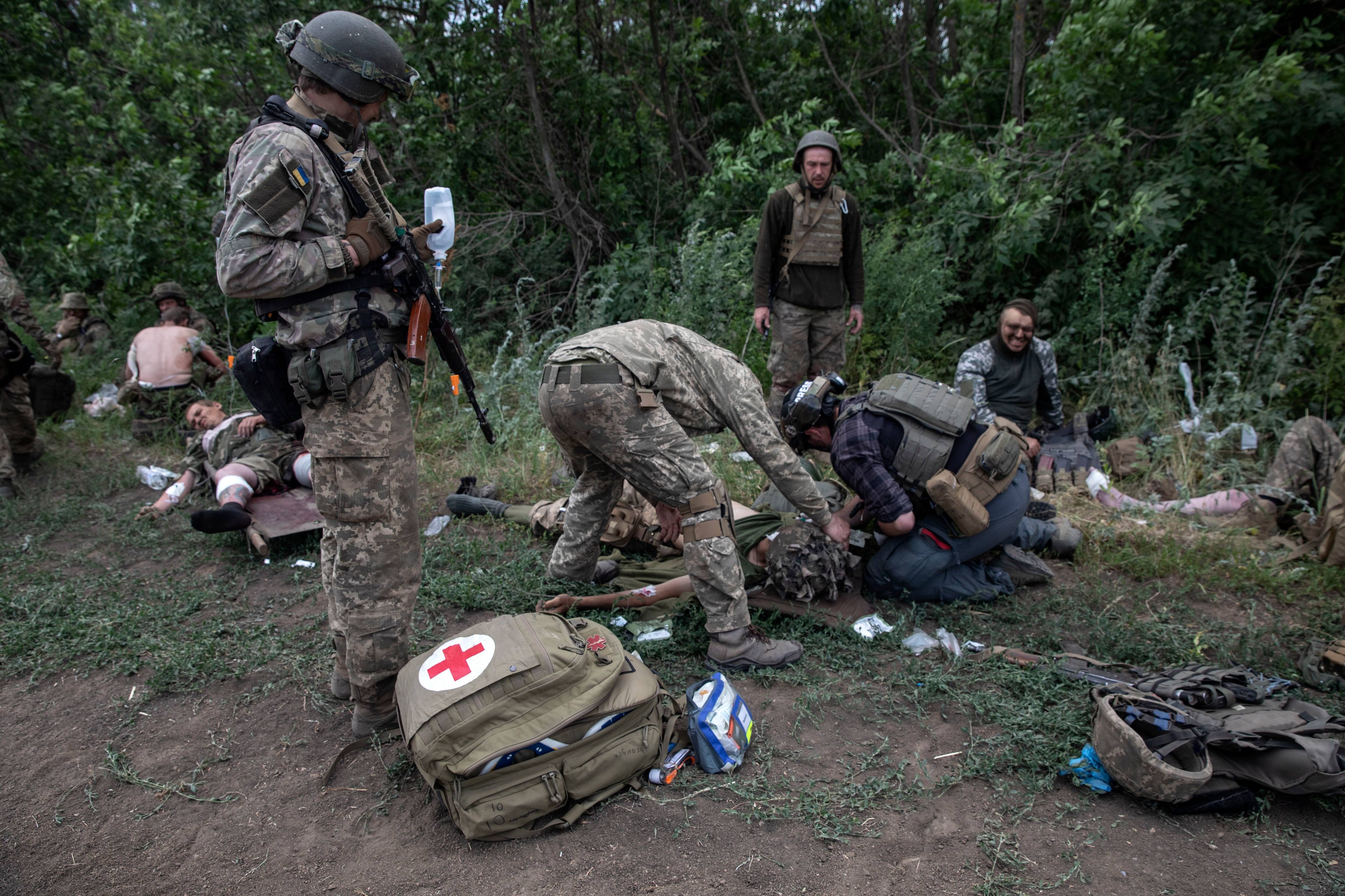 While waiting for evacuation teams, two medics try to stanch bleeding and assess the severity of injuries. (Heidi Levine for The Washington Post)