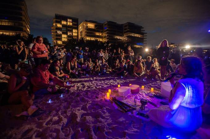 People attend a community vigil on the beach for those missing after the collapse of the Champlain Towers South condominium building. (Giorgio Viera/AFP/Getty Images)