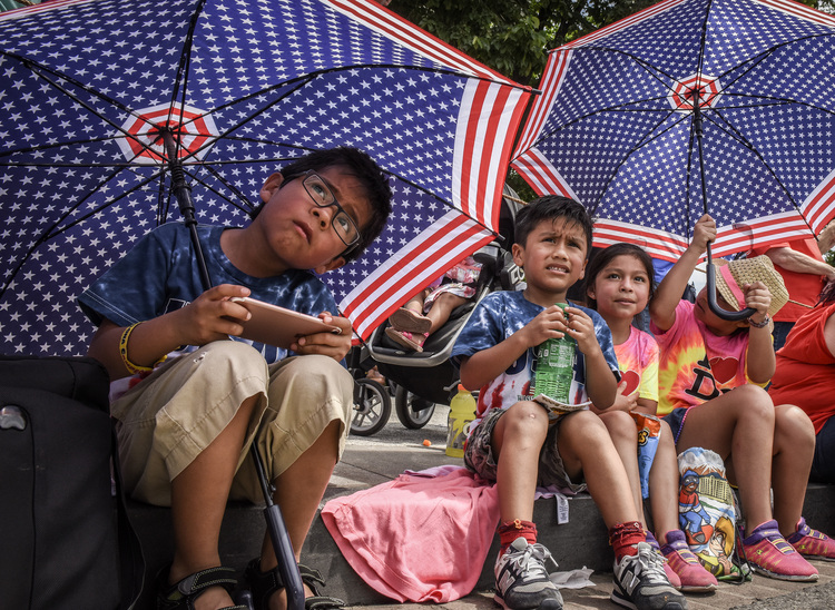 Daniel De la Torres, left, watches the National Independence Day with his cousins yesterday in Washington, DC. (Bill O'Leary/The Washington Post)</p>