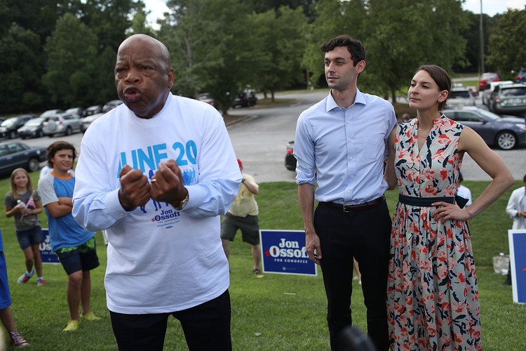 Jon Ossoff and his fiance, Alisha Kramer, listen as John Lewis speaks on Saturday. (Joe Raedle/Getty Images)</p>  
