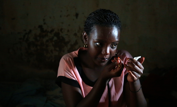 Angel puts on makeup before going to church in Ngoma Sector, Rwanda. (Whitney Shefte / The Washington Post)</p>  